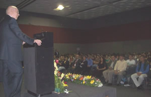 Lyn da discurso en el auditorio